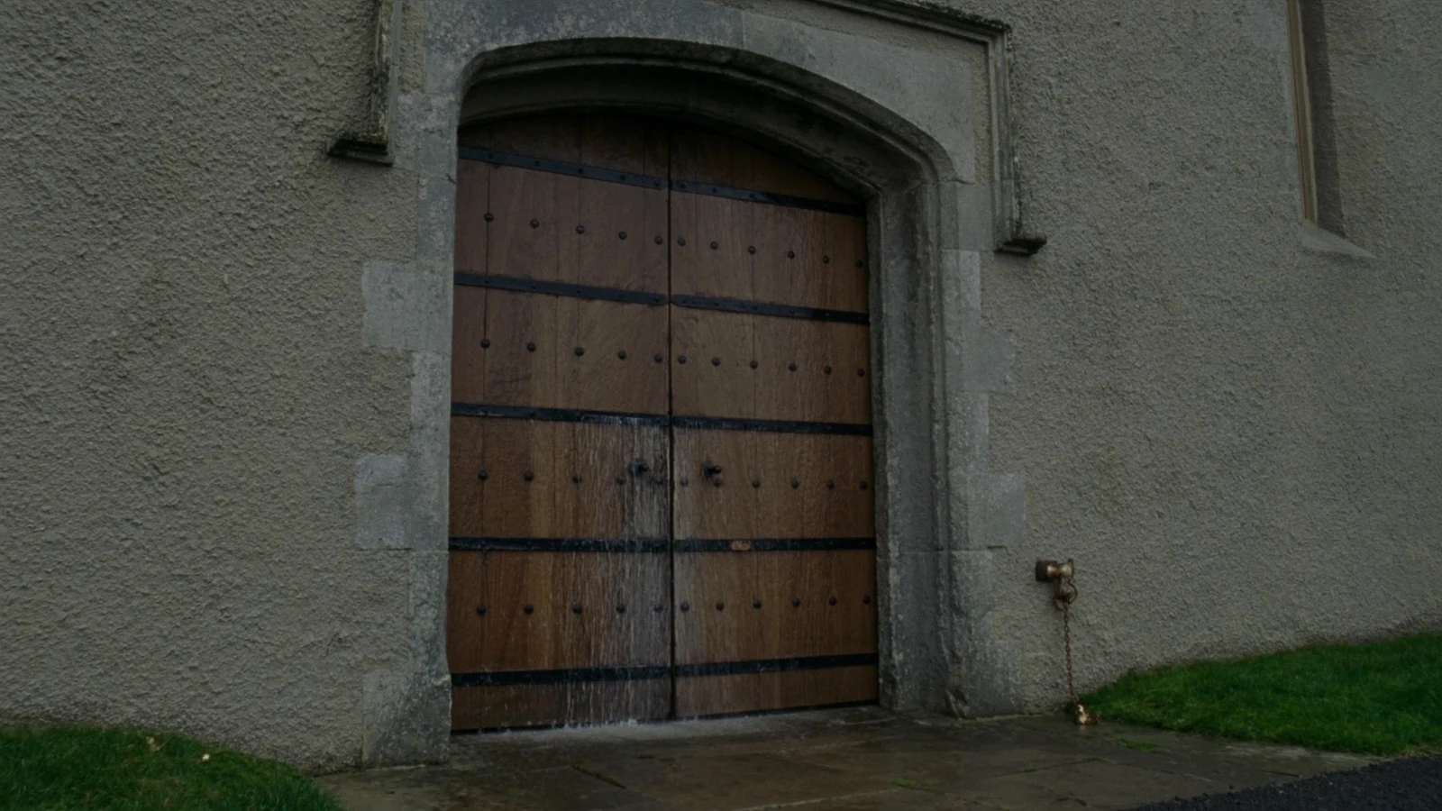 The closed iron-studded castle door at the end of Meredith’s journey