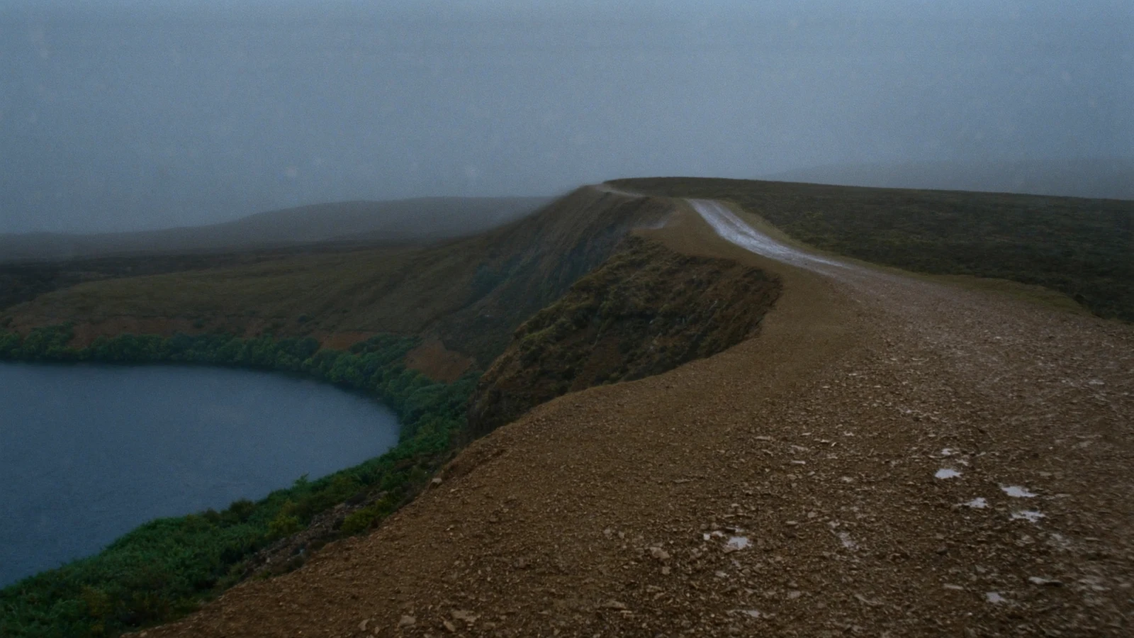 Rain sweeps across the Highland path above the loch